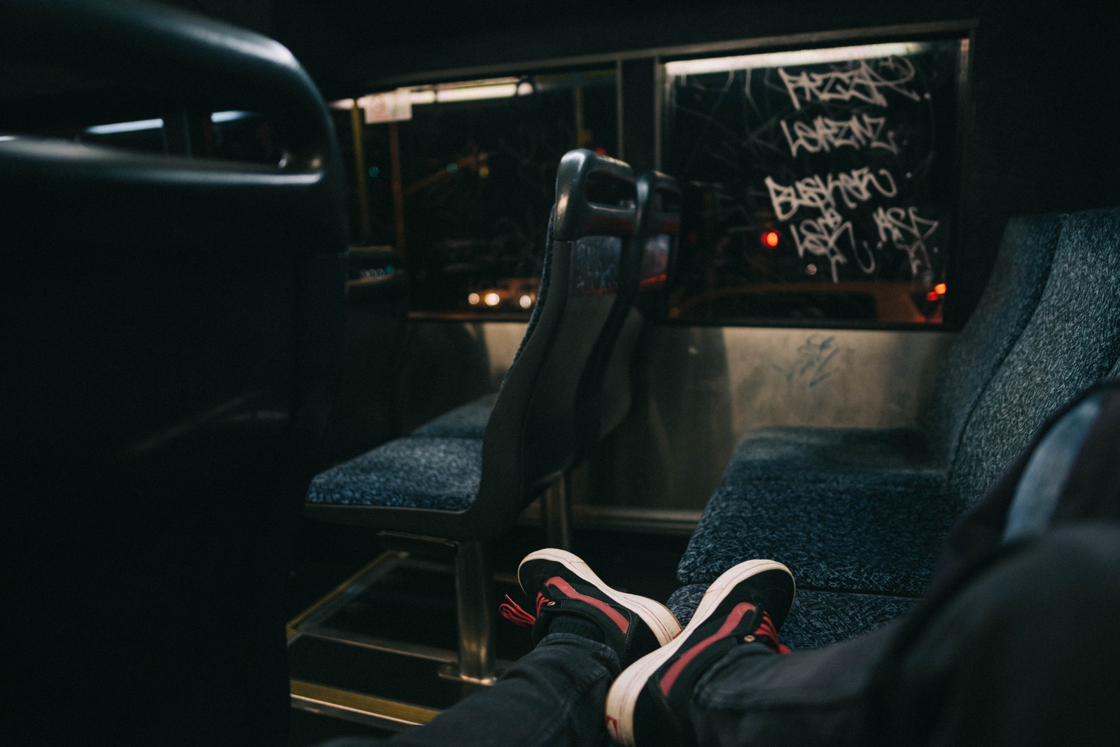 Someone is sitting in a bus with their feet up (transport, car, public transport, auto part, driving)