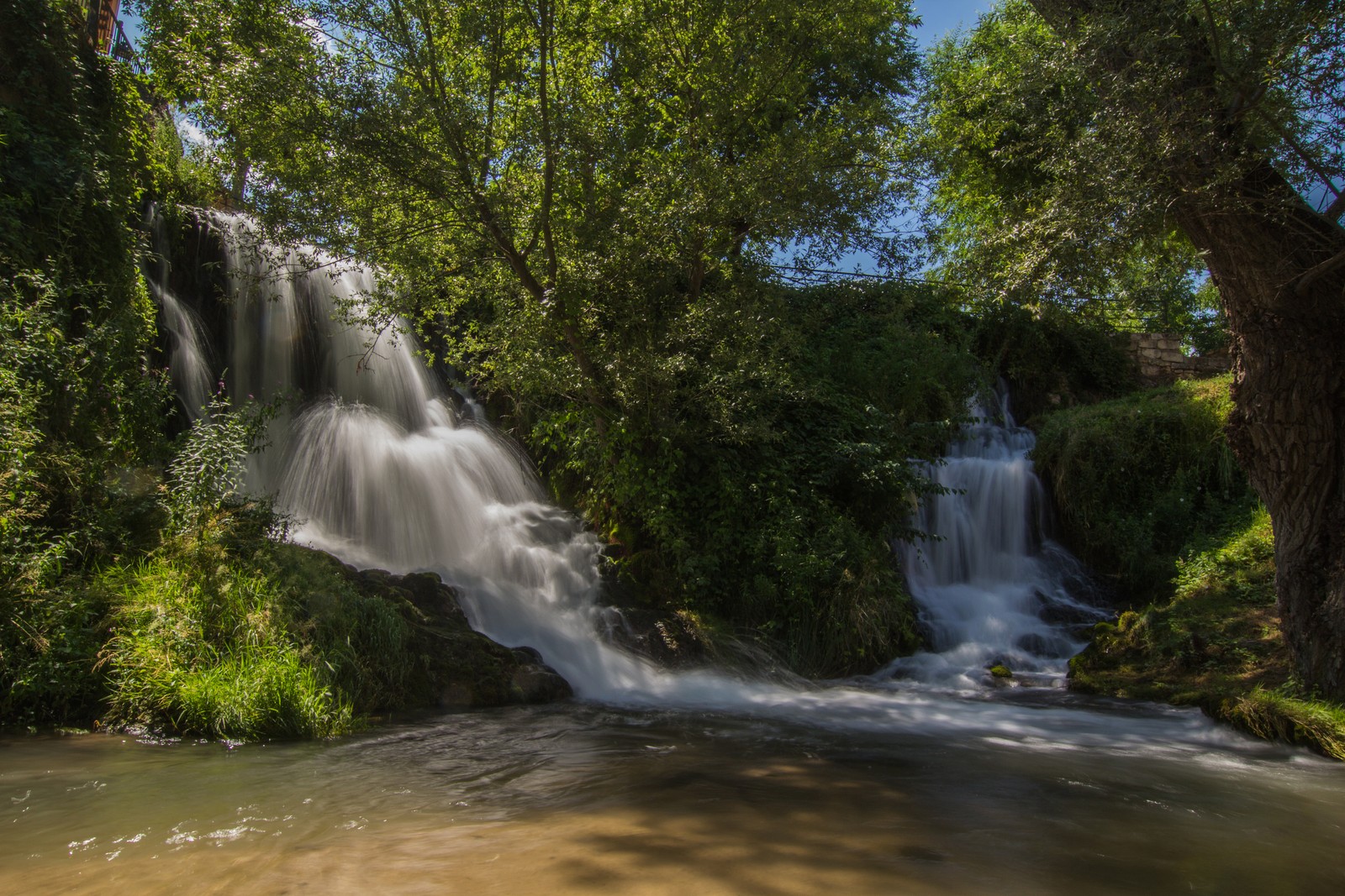 Крупный план водопада в лесу с деревьями (водопад, водоем, водные ресурсы, природа, вода)