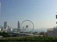 Paisagem urbana com roda-gigante e edifícios altos