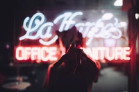 Silhouette Against Neon Office Sign: A Blend of Red and Magenta Glow