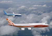 Boeing 747-8 and Boeing 787 Dreamliner in flight above the clouds.