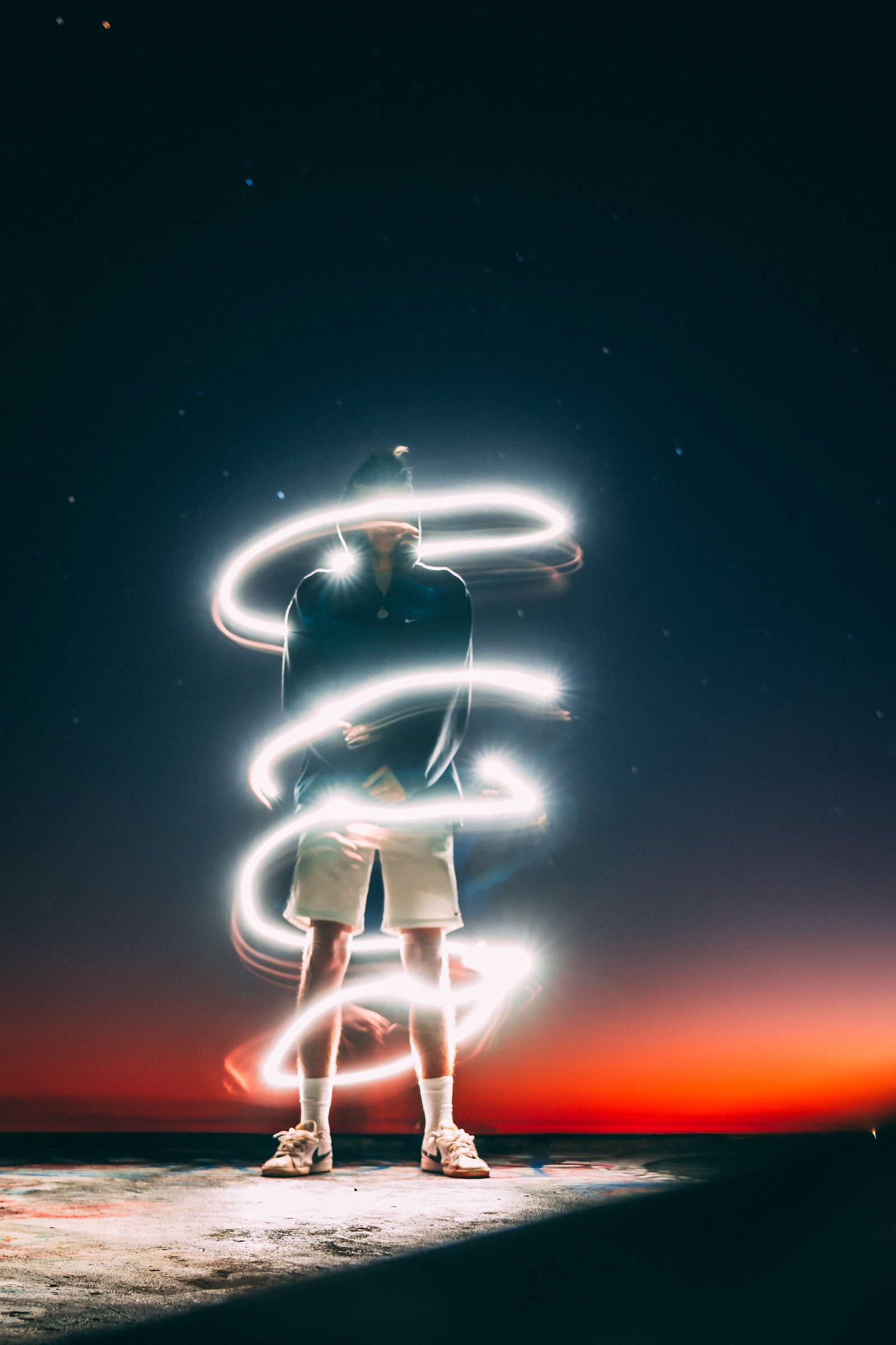 Arafed image of a man standing on a beach with a hula hoop (light, neon, space, night, illustration)