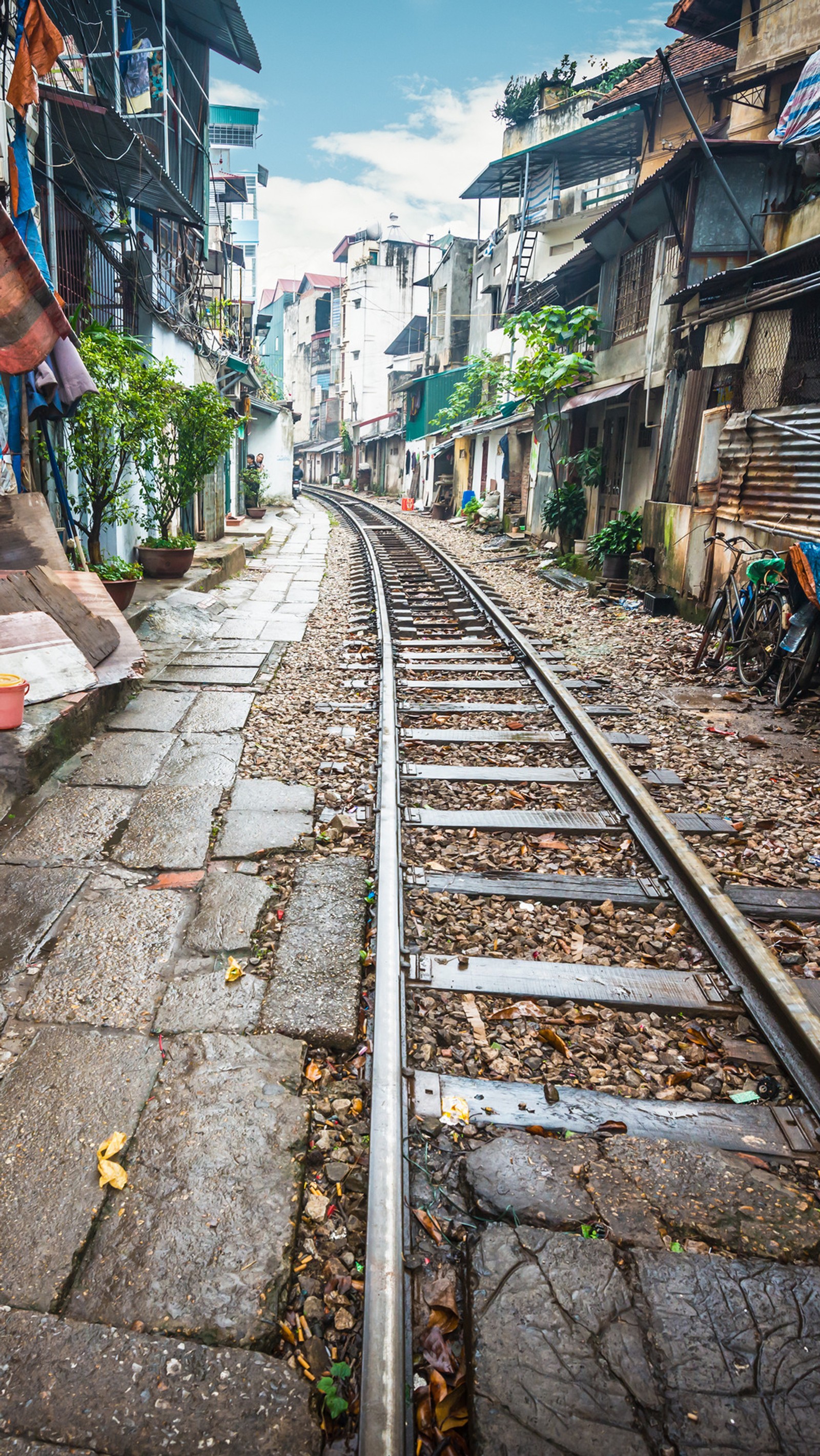 There is a man riding a skateboard down a street (hanoi, train, street, road, travel)