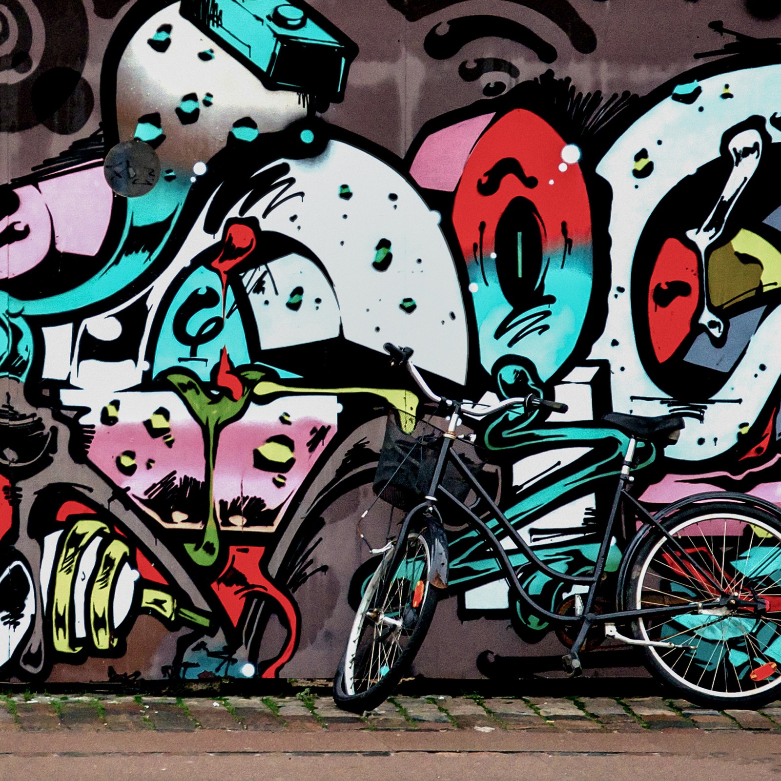 Graffiti an einer wand mit einem fahrrad, das dagegen gelehnt ist (graffiti, rad, fahrrad, reifen, schwarz)