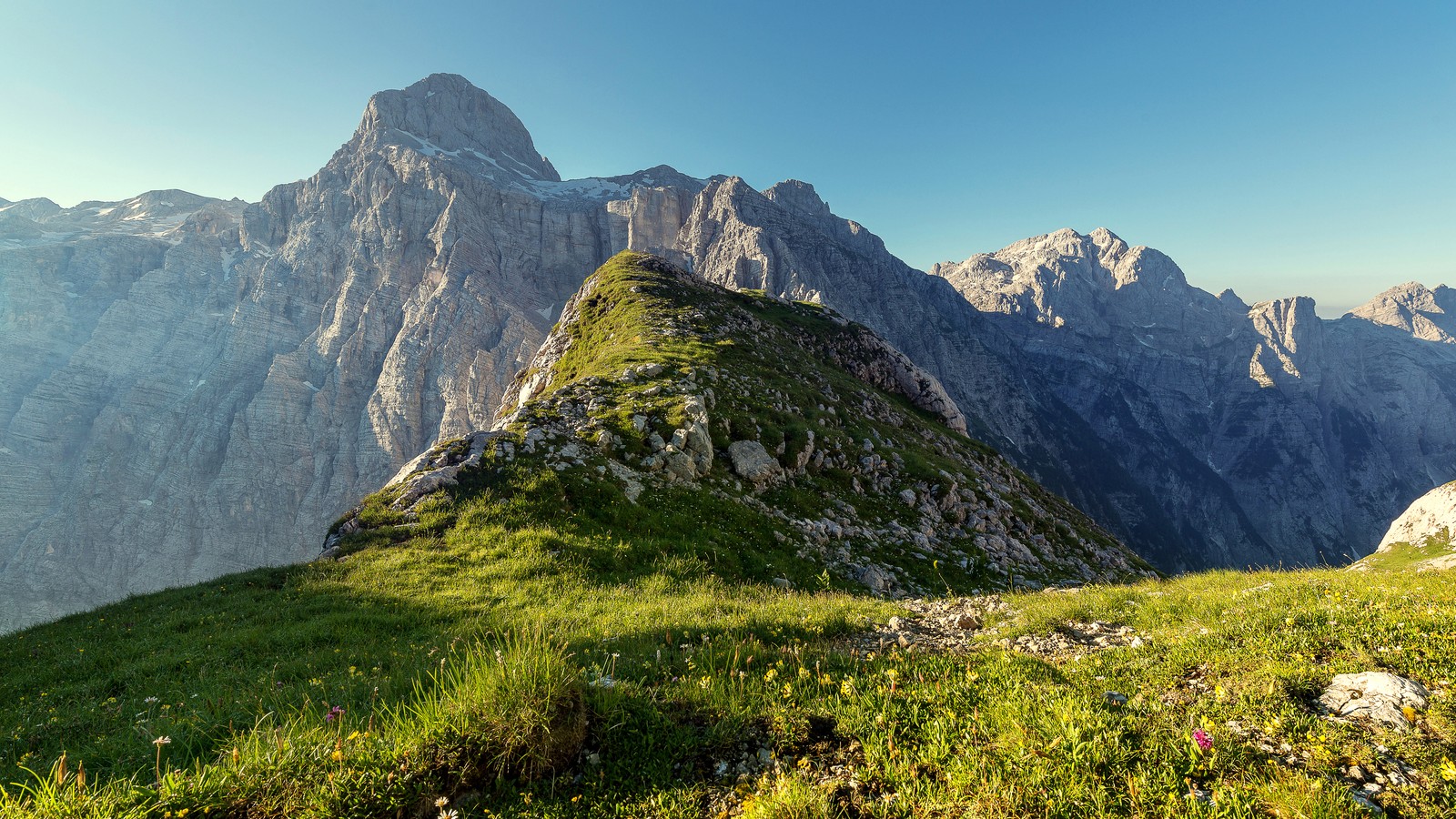 A view of a grassy mountain with a few rocks and grass (triglav national park, landscape, slovenia, alps mountains, nature)