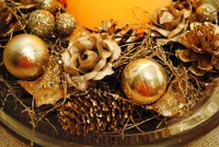 Elegantes Weihnachts-Tischmittelstück mit metallischen Ornamenten und Tannenzapfen