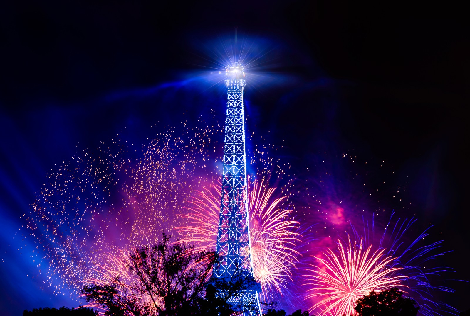 Les feux d'artifice s'allument dans le ciel derrière une tour (tour eiffel, feux dartifice, bastille day, nuit, paris)