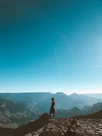 Aventureiro em pé em uma crista sob um céu azul