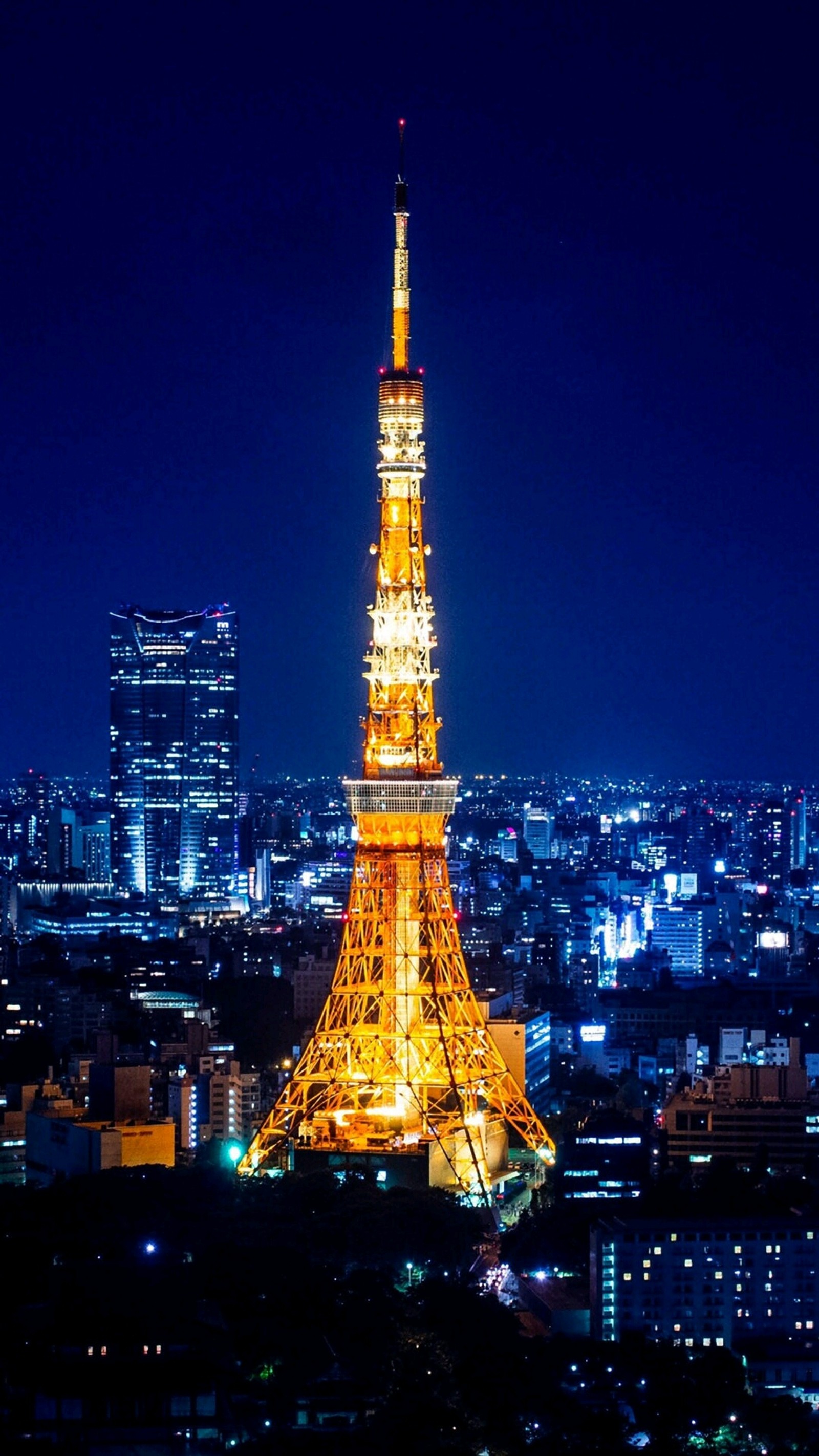 Vista aérea de uma cidade à noite com uma torre alta (eyfel, paris)