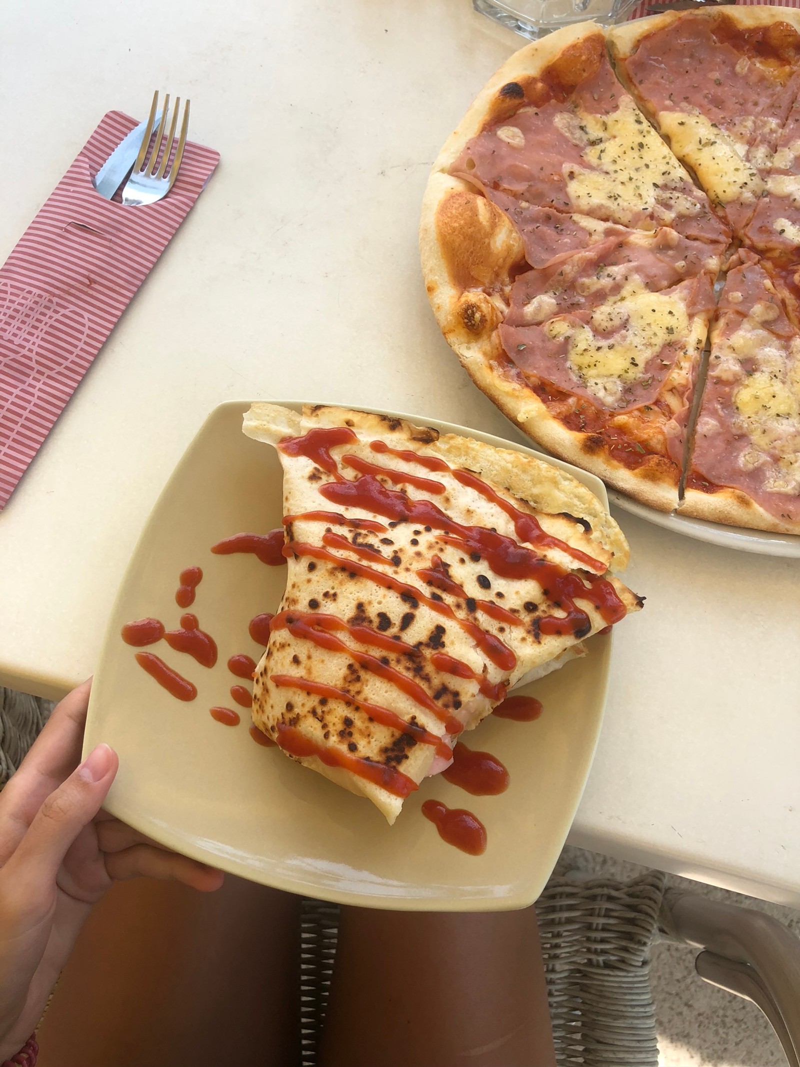 Hay una persona sentada a una mesa con un plato de pizza (pizza, desayuno, comida, cocina, platos)