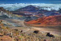 Majestuoso cráter volcánico rodeado de majestuosas cadenas montañosas y nubes ondulantes