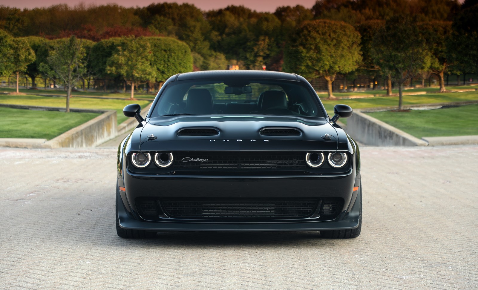 A black dodge charger parked in front of a park (dodge challenger srt black ghost, 2023, cars, 4k wallpaper)