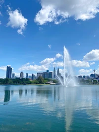 Urban Oasis: Fountain Reflections in a City Lake