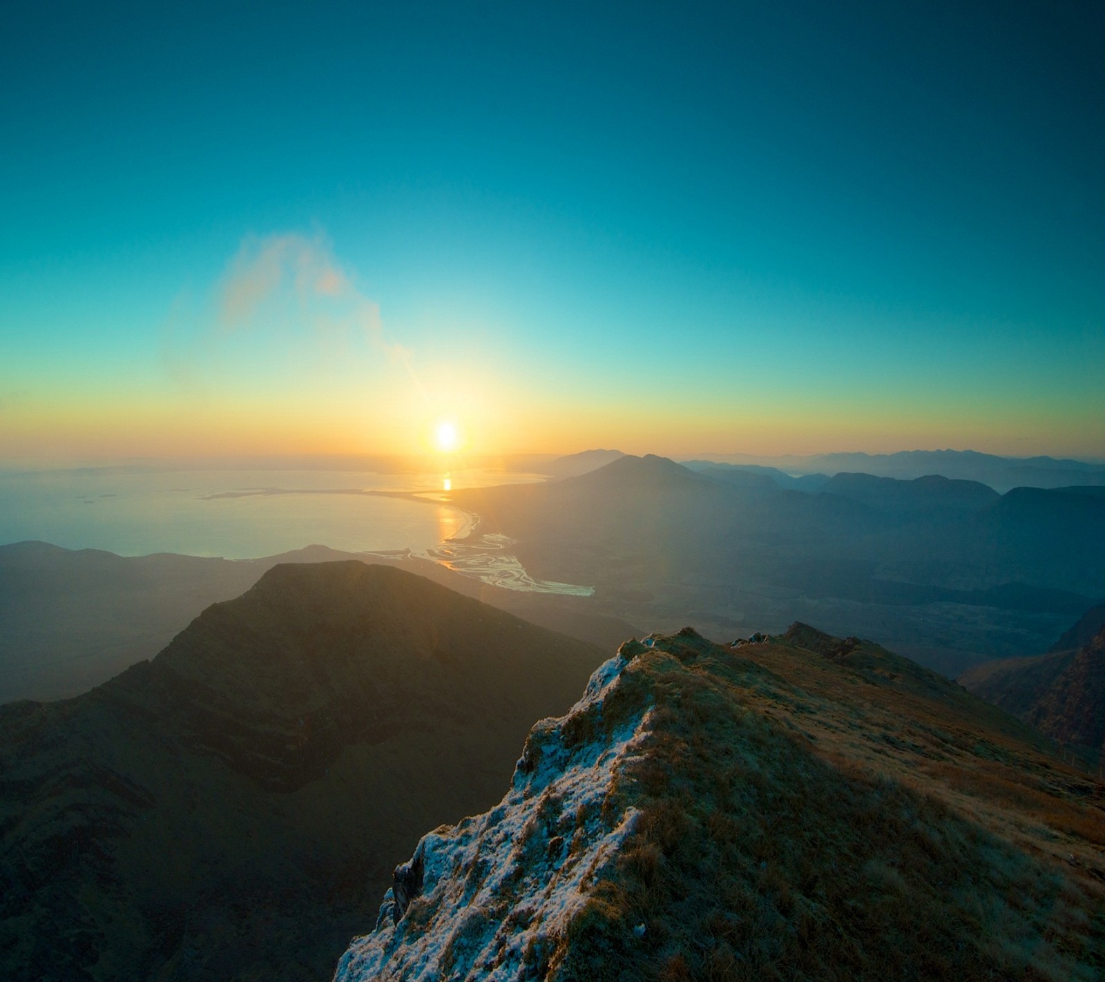 Vue aérienne d'une montagne avec un coucher de soleil au loin (montagnes, nature)