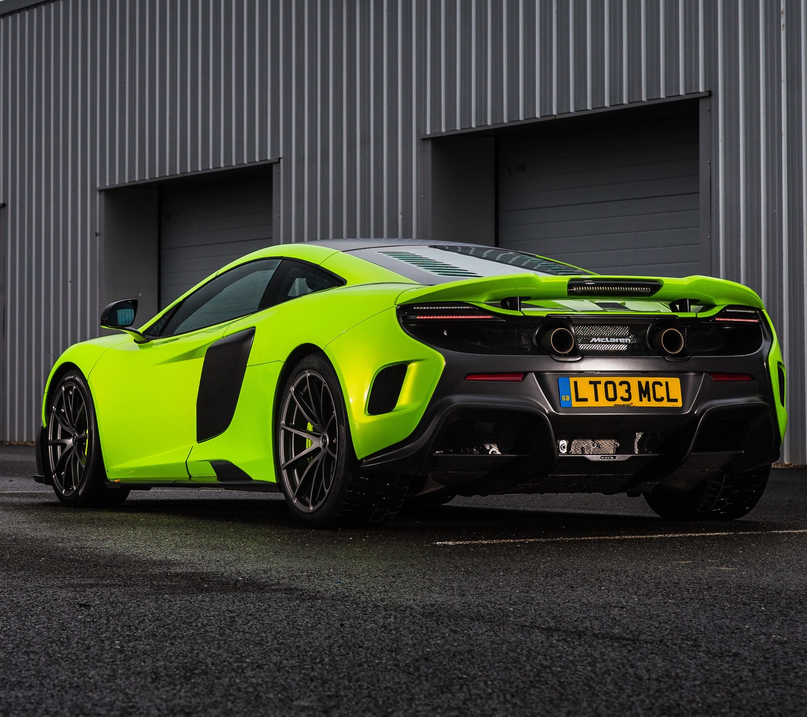 A close up of a yellow sports car parked in front of a building (675lt, auto, car, mclaren)