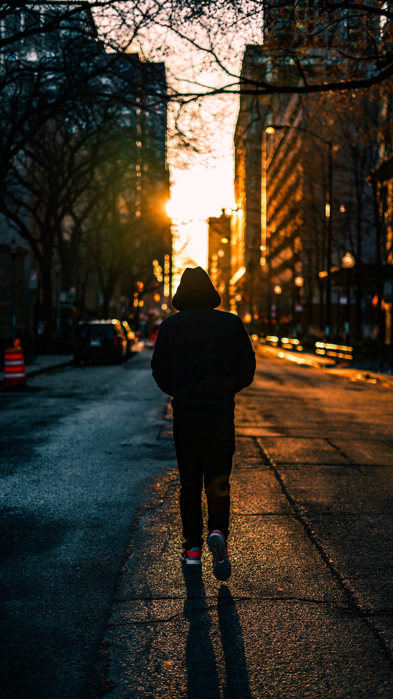 Uma pessoa árabe caminhando pela rua ao pôr do sol com um capuz (afastando se, cidade, humor, menino, por do sol)