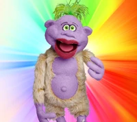 Lila Puppe Peanut von Jeff Dunham vor einem lebhaften Regenbogenhintergrund