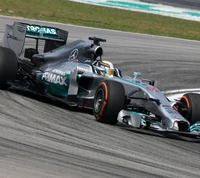 Lewis Hamilton racing in a Mercedes-Benz F1 car on the track.