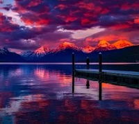 Majestuoso atardecer sobre un lago sereno y montañas