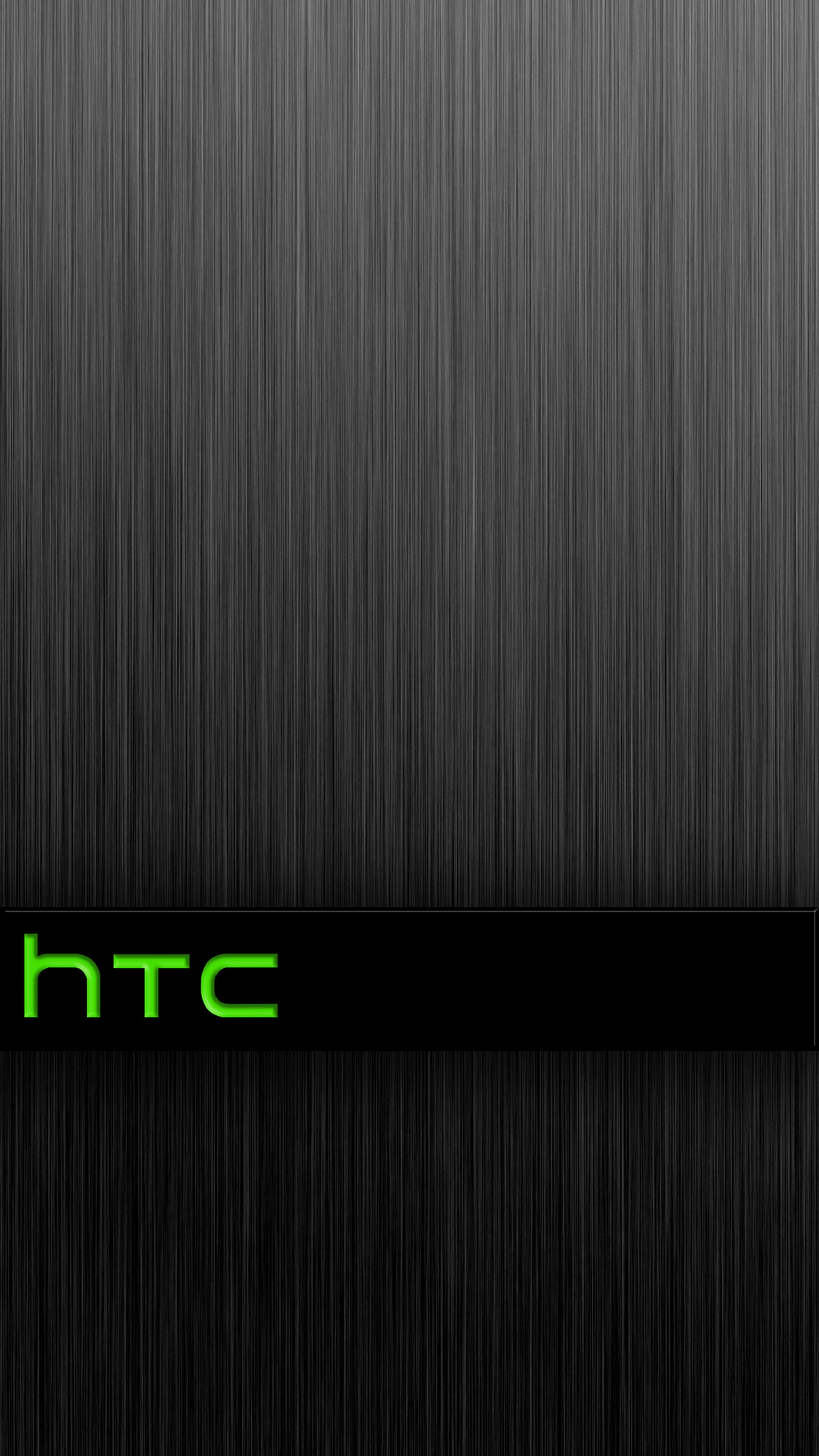 A close up of a black and green logo on a metal surface (green, htc, steel)