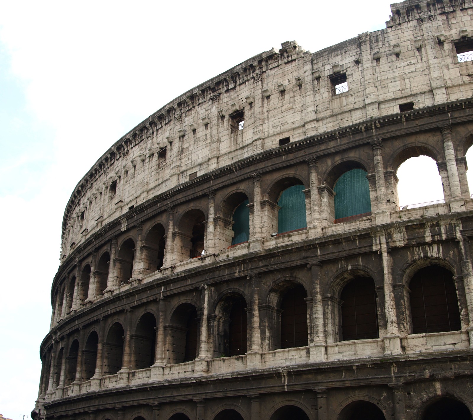 Uma visão de um grande edifício com arcos (coliseu, itália, roma, turismo, viagem)