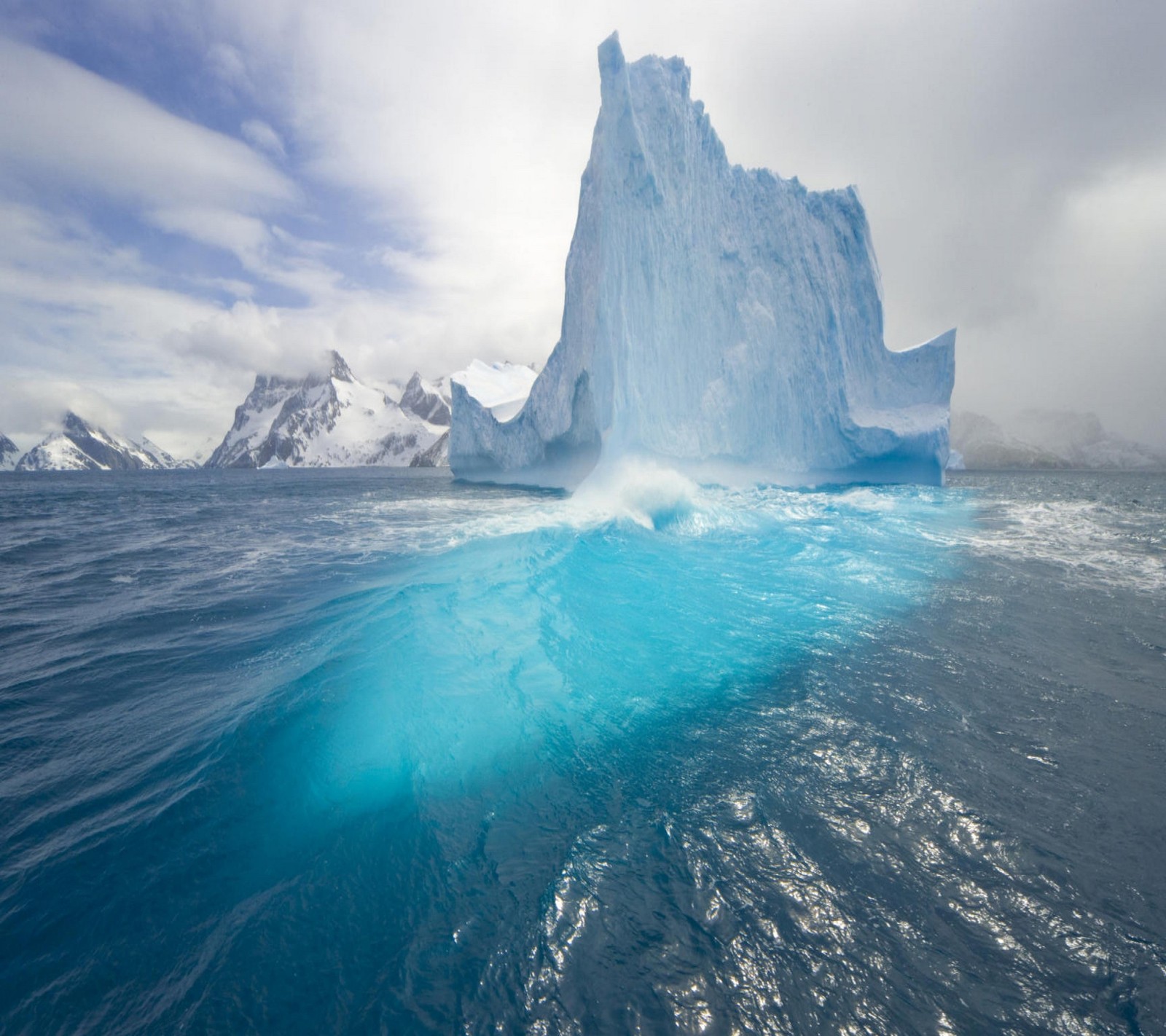 Un iceberg flotante en el océano com agua azul (paisaje, naturaleza)