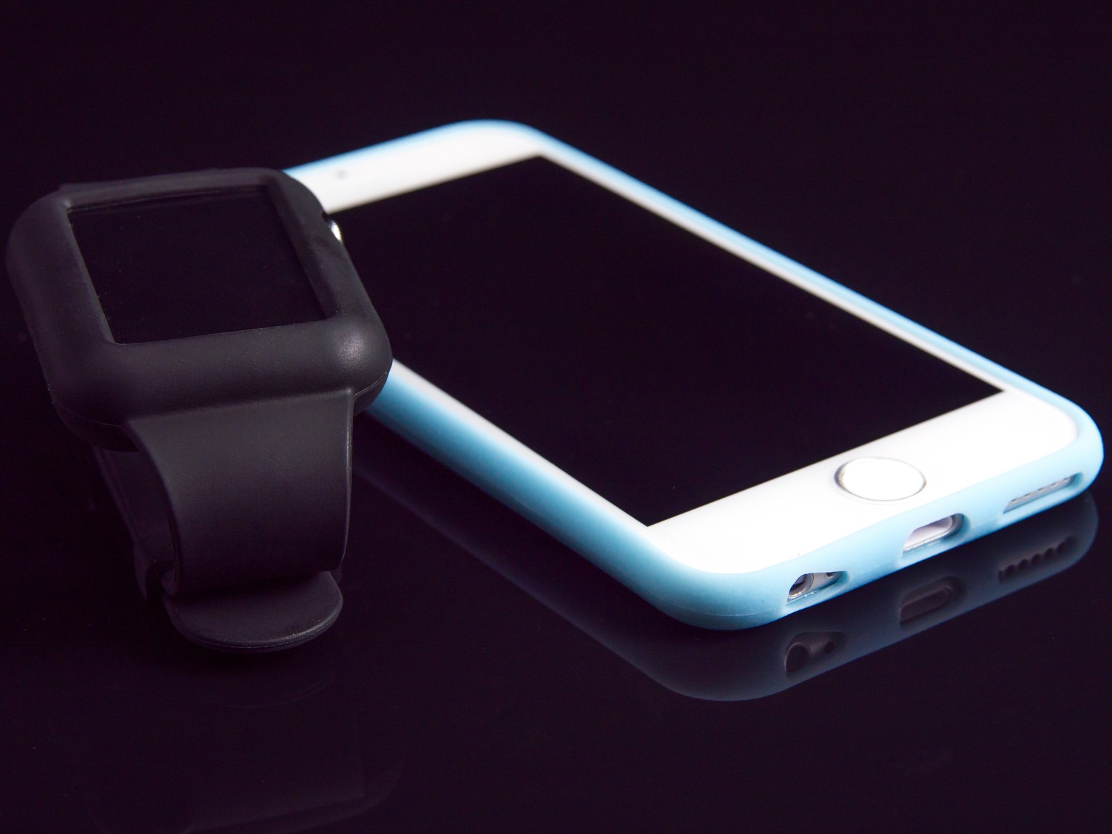 There is a smart phone and a smart watch on a table (communication device, smartphone, watch, apple, smartwatch)