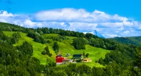 Paysage vibrant des Highlands avec des pâturages et des fermes colorées contre un majestueux arrière-plan de montagne.