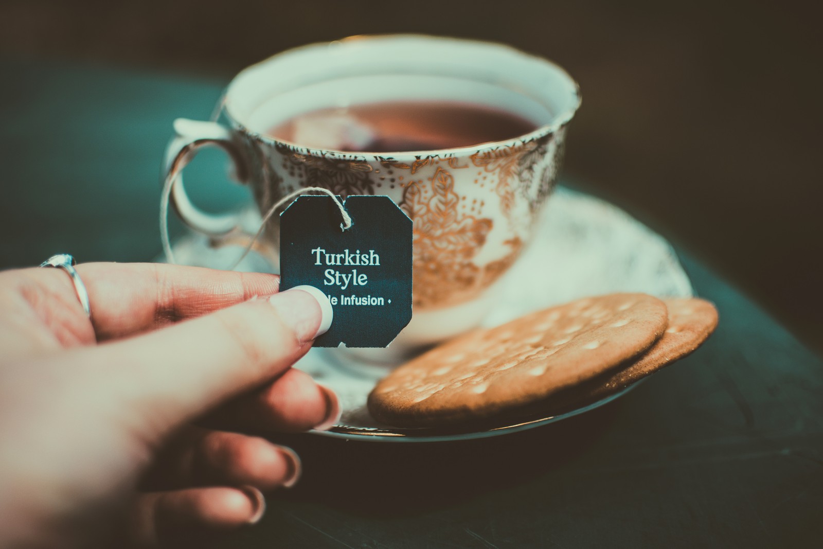 Alguien sosteniendo una etiqueta que dice estilo turco con una galleta (té, té verde, bolsa de té, taza de café, taza)