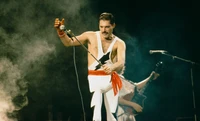 Freddie Mercury fesselt das Publikum mit einer dynamischen Performance auf der Bühne und verkörpert das Wesen von Rock und Unterhaltung.