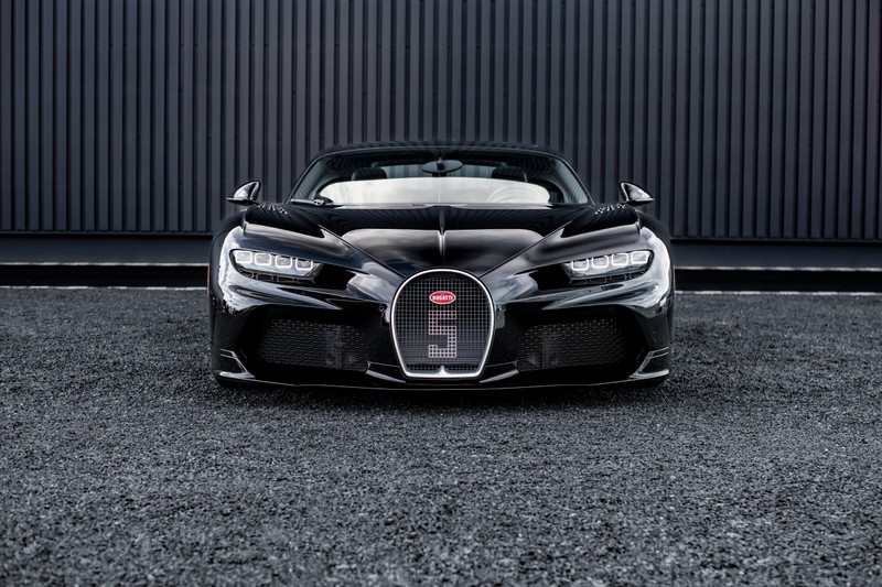 Близкий план автомобиля bugatti, припаркованного перед зданием (bugatti chiron super sport, черные автомобили, 5k, 2024, машины)