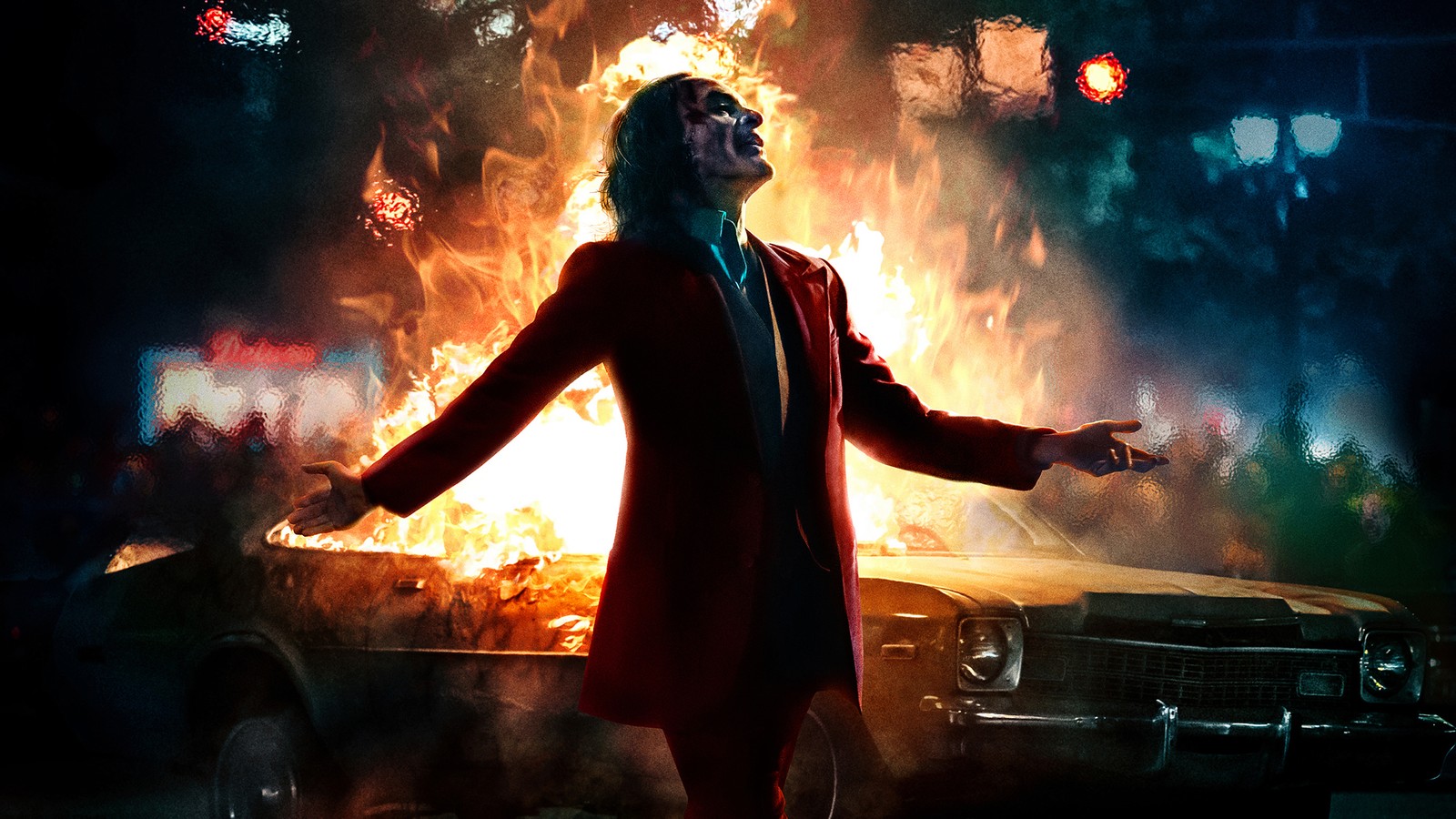 Bild eines mannes in einem roten anzug, der vor einem auto mit flammen steht (joker 2019, film, joker, plakat, joaquin phoenix)