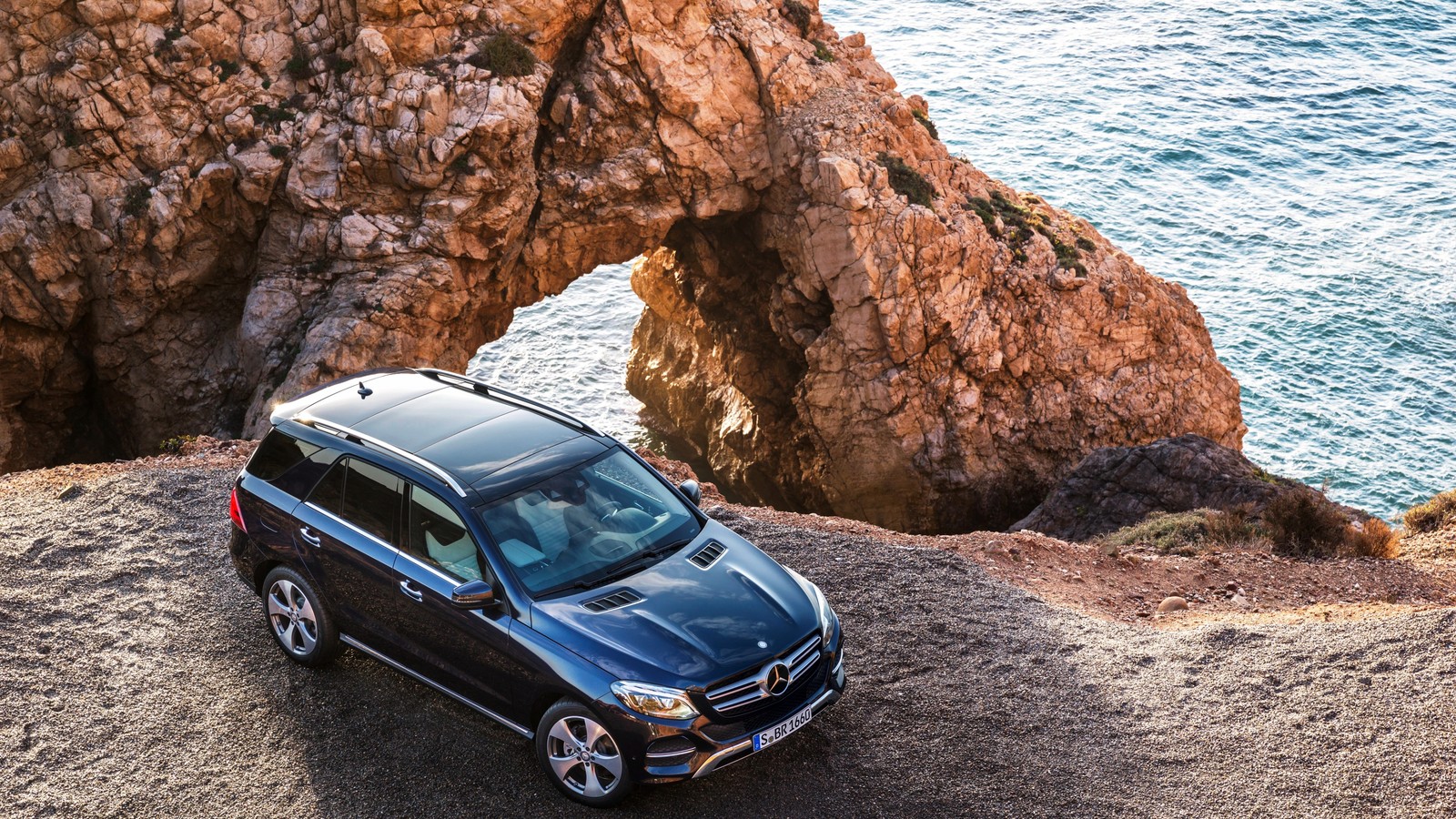 A black mercedes suv parked on a rocky cliff near the ocean (transport, road trip, motor vehicle, new york international auto show, off roading)