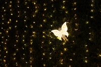 Mariposa iluminada en un jardín nocturno estrellado