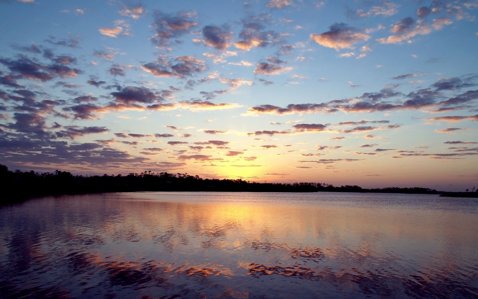 Vista aérea de un lago con un atardecer de fondo (reflexión, naturaleza, agua, nube, horizonte)