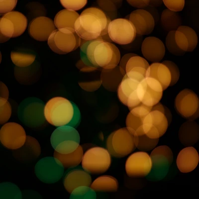 Bokeh simétrico de círculos amarelos e verdes na escuridão