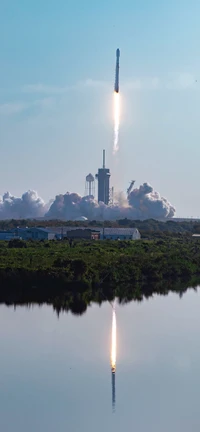 Lançamento do foguete Falcon 9 refletido em águas tranquilas