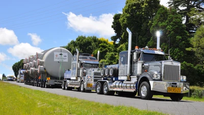 Camion Kenworth surdimensionné transportant de l'équipement industriel le long des arbres