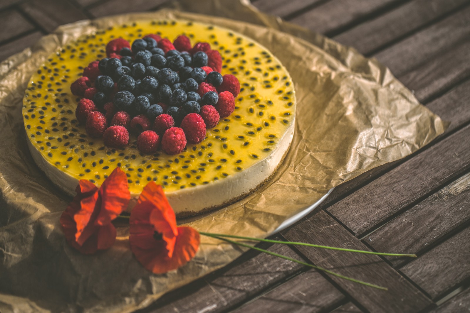 Hay un pastel con bayas y arándanos sobre una mesa (tarta de queso, postre, pastel, comida, planta)