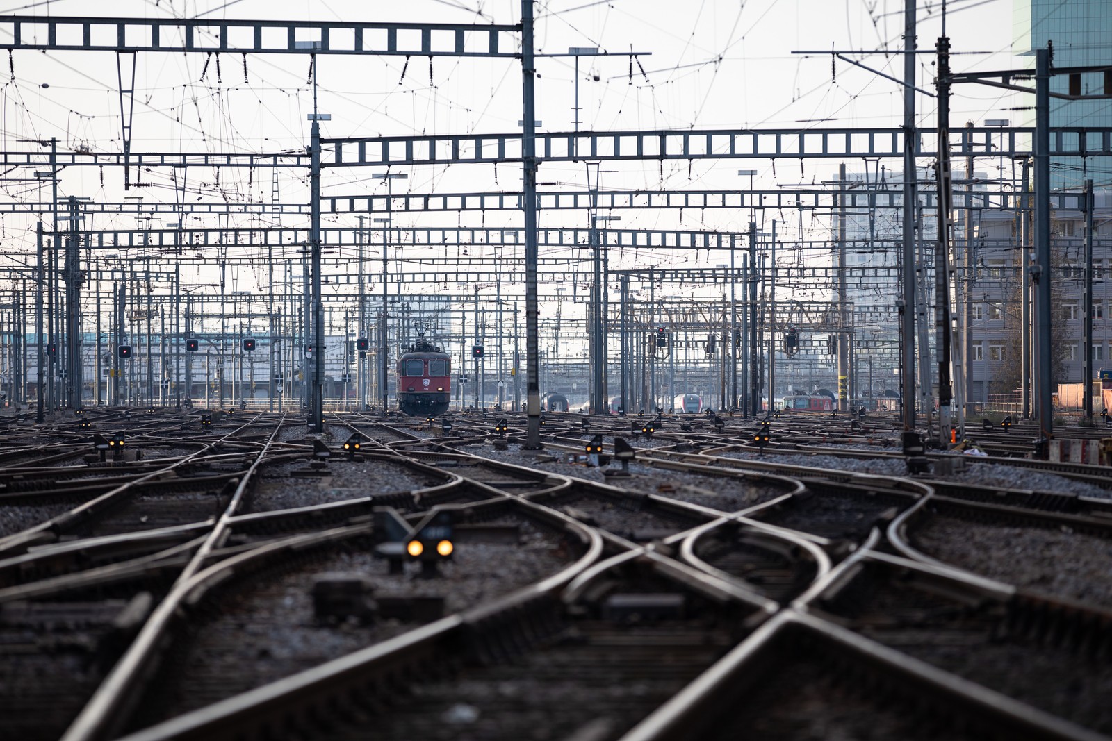 Hay un tren que va por las vías en la ciudad (transporte ferroviario, tren, estación de tren, pista, transporte)