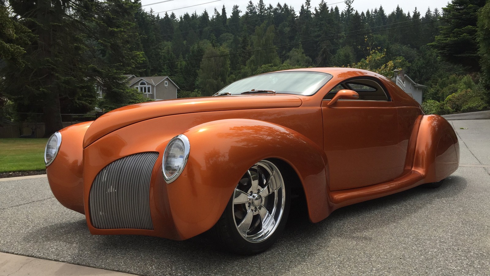 Gros plan d'une voiture garée dans une rue près d'une forêt (lincoln, voiture, hot rod, muscle car, coup)