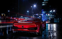 Réflexion nocturne d'une voiture de sport rouge par les lumières de la ville