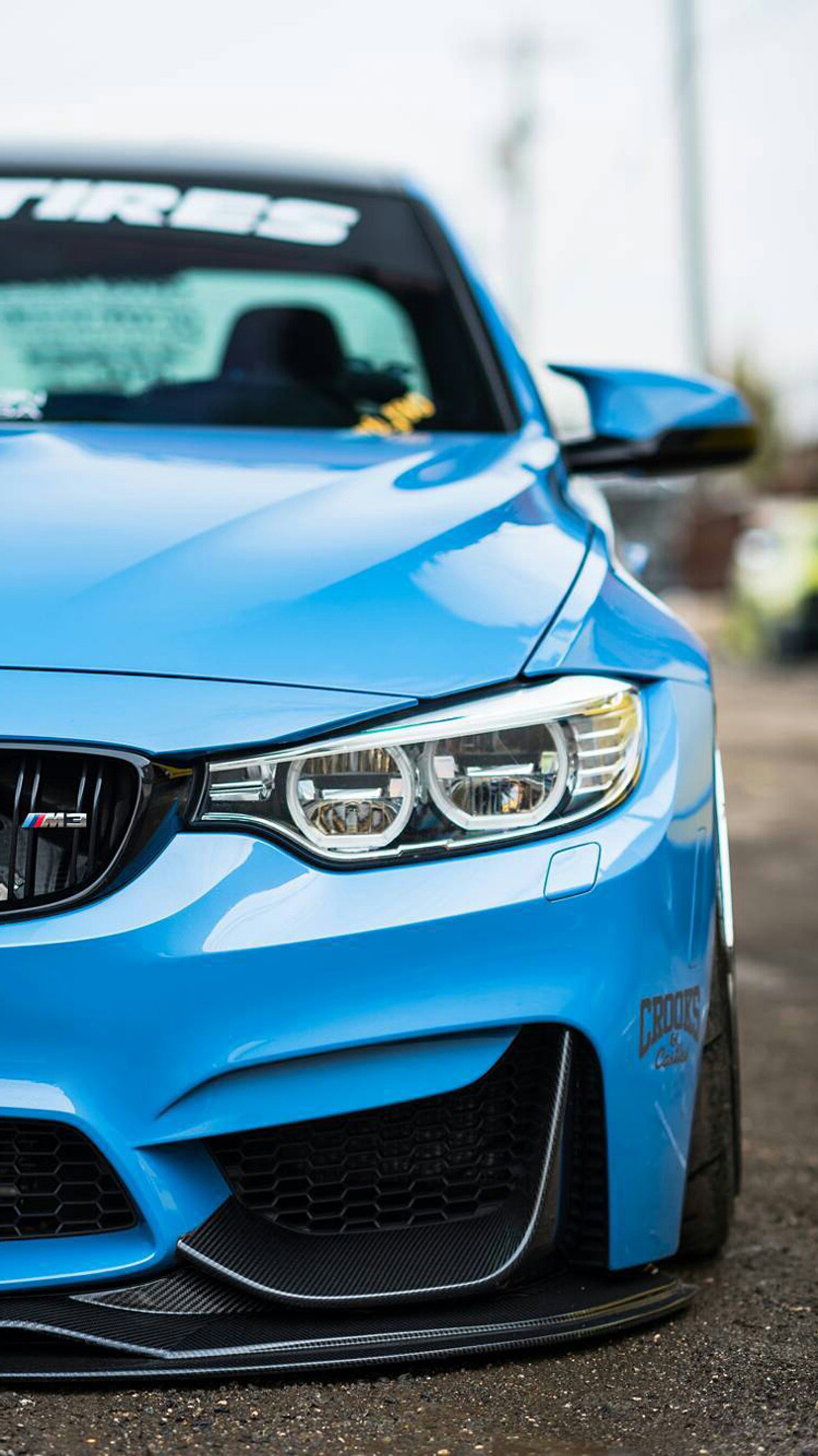 Un primer plano de un coche bmw azul estacionado en un aparcamiento (bmw, coche, f80, vista frontal, m3)