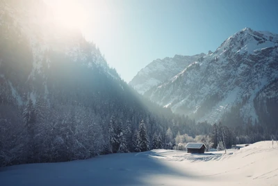 Paysage enneigé avec des montagnes majestueuses et un chalet serein sous un soleil éclatant.