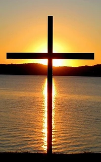 Cross Silhouetted Against a Sunset Over the Sea