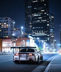 Mazda RX-7 FD modifié dans un paysage urbain nocturne