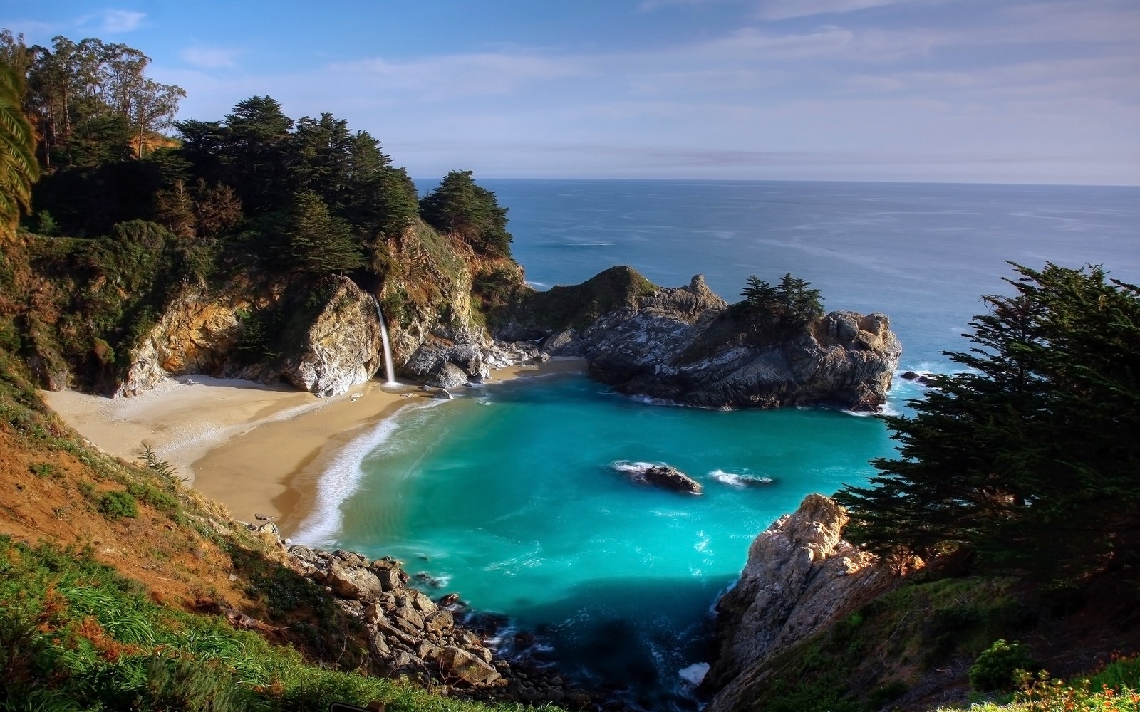 Una vista de una playa con un cuerpo de agua y un acantilado (parque, parque estatal, cascada, cuerpo de agua, costa)