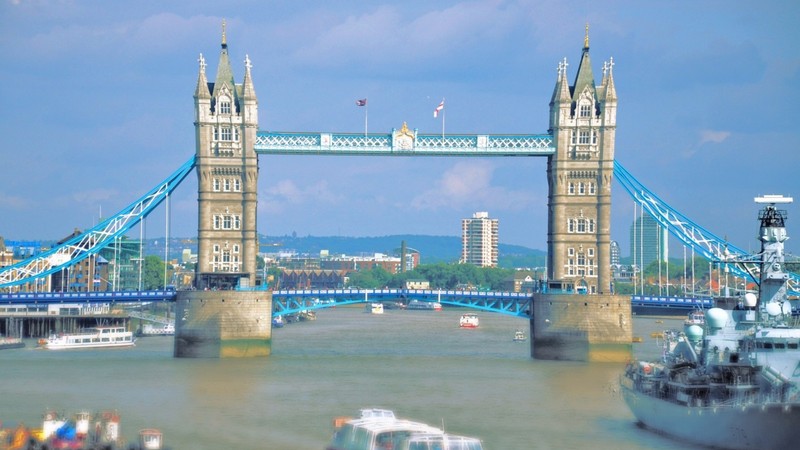 Лодки находятся в воде рядом с мостом с флагом на нем (tower bridge, мост, достопримечательность, башня, город)