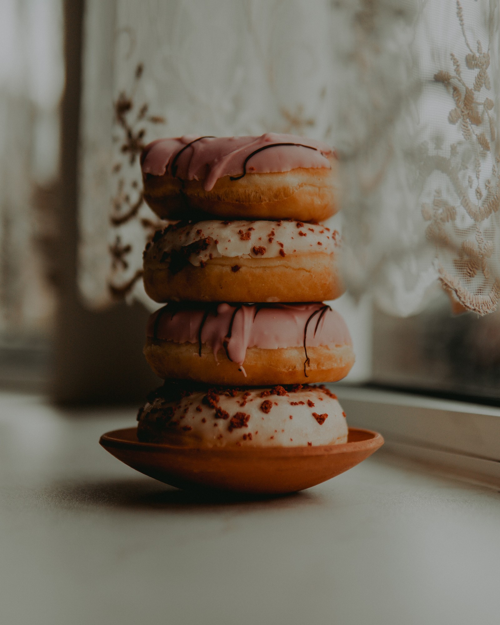 Hay tres donuts apilados uno sobre el otro en un plato (plato, snack, cocina, postres, macarón)