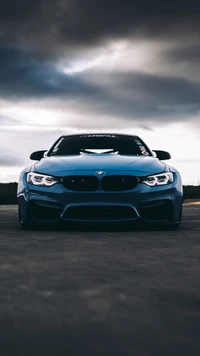 BMW M3 élégant avec une posture agressive sous un ciel dramatique.